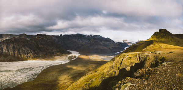 Scenic view of mountains against cloudy sky