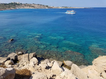 Sailboats on sea shore against sky