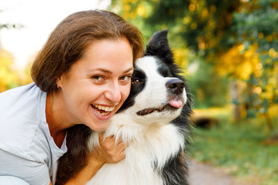 Woman embracing dog snout at park