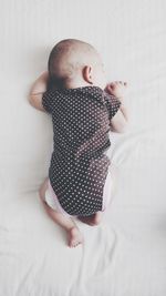 High angle view of baby lying on bed