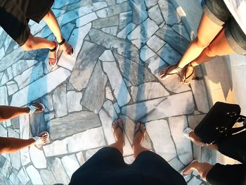 Low section of people standing on tiled floor