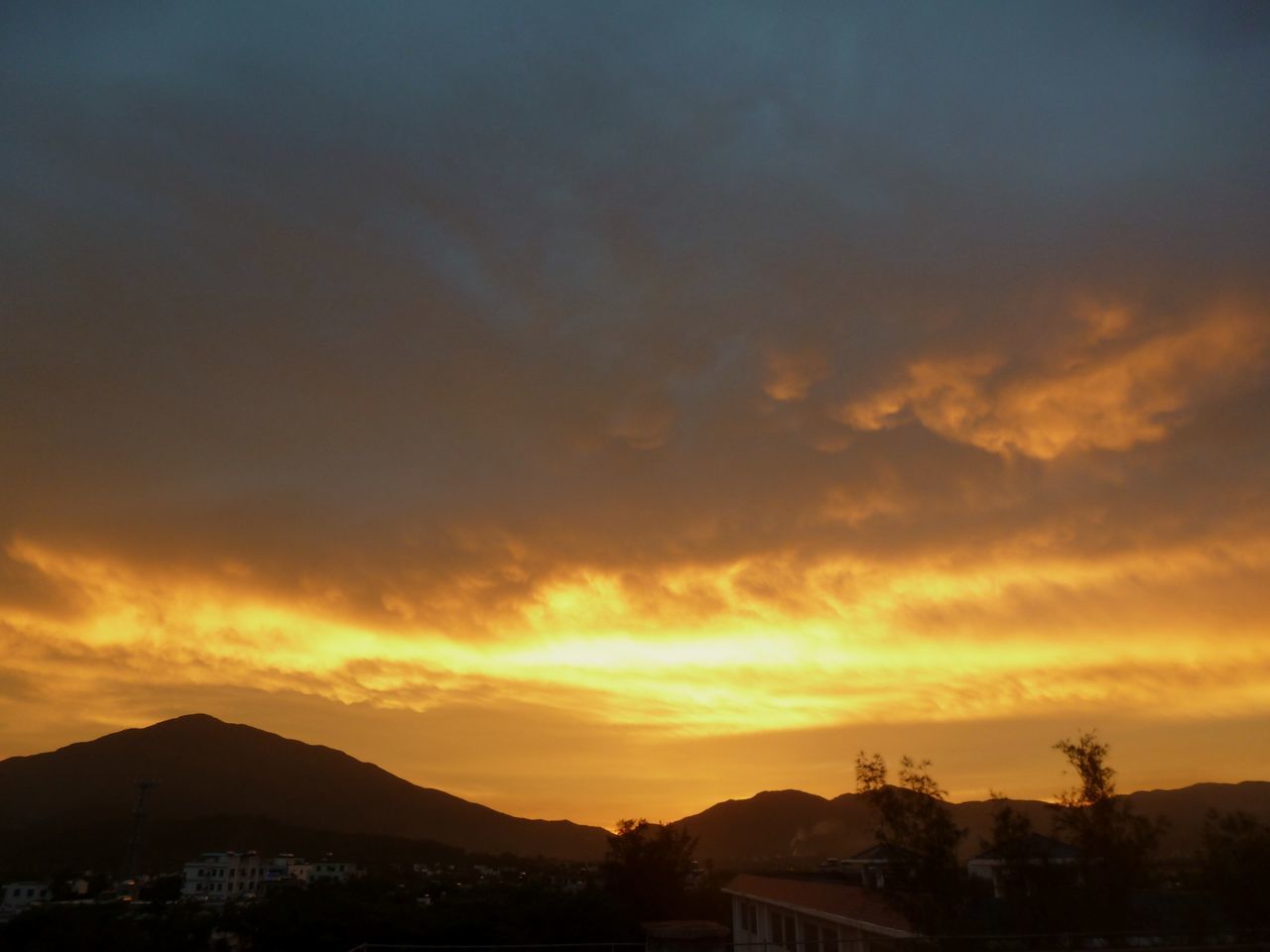 sunset, orange color, sky, mountain, silhouette, scenics, cloud - sky, beauty in nature, built structure, building exterior, architecture, tranquil scene, nature, dramatic sky, cloud, tranquility, mountain range, idyllic, house, outdoors