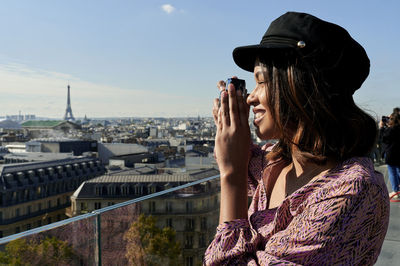 Tourist taking photo of eiffel tower through camera, paris, france