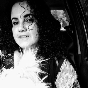 Portrait of young woman looking away while sitting in car
