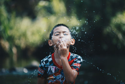 Portrait of boy spitting water