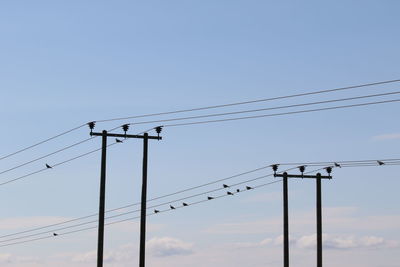 Low angle view of silhouette electricity pylon against clear sky