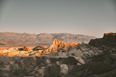 Morning sunlight on a prominent rock formation against a clear sky