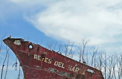 Low angle view of information sign against sky