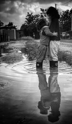 Full length of children on puddle during rainy season