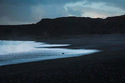 Scenic view of sea and mountains against sky