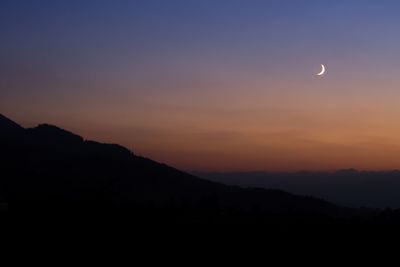 Scenic view of silhouette mountains against sky at night