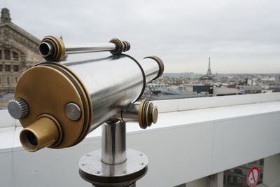 Close-up of coin-operated binoculars against sky