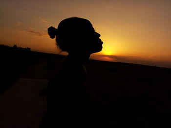 Silhouette woman against sky during sunset