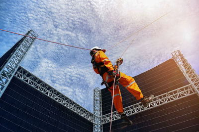 Low angle view of man working at construction site against sky