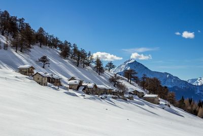 Scenic view of snow covered landscape and mountains against sky