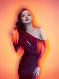 Portrait of a young woman against red background