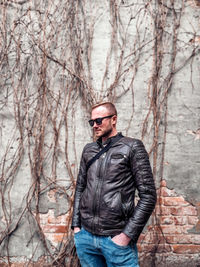 Portrait of man standing against bare tree