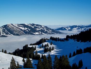 Scenic view of snowcapped mountains against clear blue sky