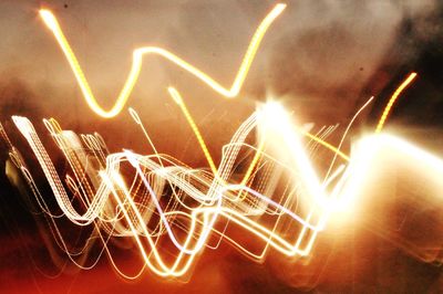 Close-up of illuminated lighting equipment against sky