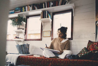 Woman sitting on sofa at home