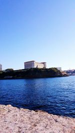 Calm sea against clear blue sky