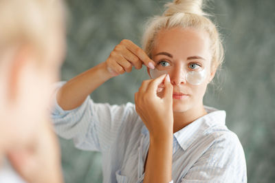 Young woman applying medical eye patch