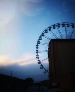 Low angle view of silhouette ferris wheel against sky