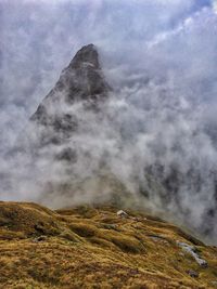 Scenic view of mountains against cloudy sky
