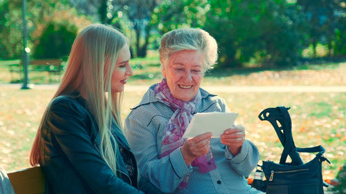 Man and woman using smart phone outdoors