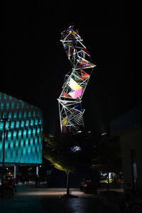 Low angle view of illuminated building against sky at night