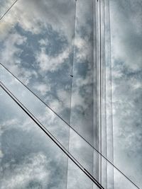 Low angle view of power cables against sky