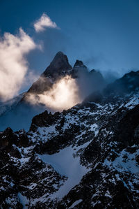 Low angle view of snowcapped mountain against sky