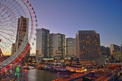 City buildings and ferris wheel come together to create a beautiful night view.