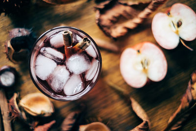 High angle view of apple cider in glass with chestnut on table