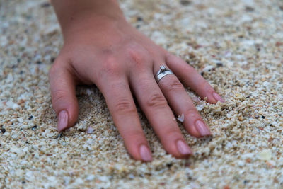 Close-up of hand touching sand