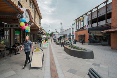 Rear view of people standing at store