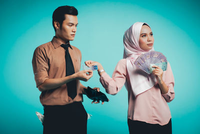 Young couple standing against blue background