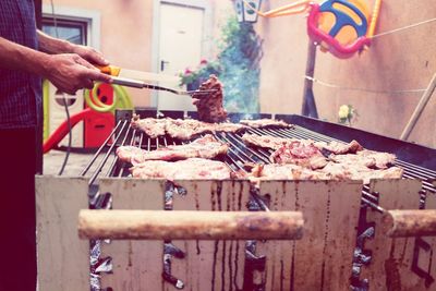 Close-up of man preparing food on barbecue grill