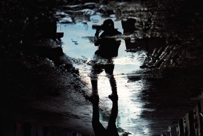 Rear view of silhouette woman standing in water