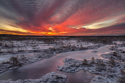 Scenic view of frozen lake against sky during sunset