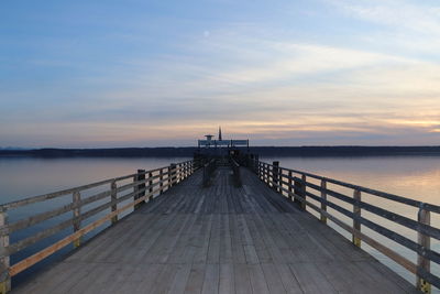 Pier over sea against sky during sunset