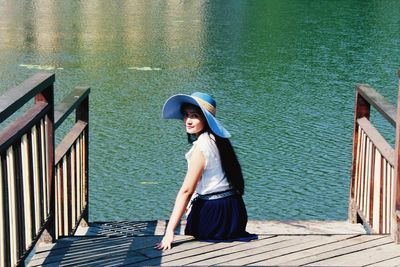 Portrait of woman sitting on steps by lake