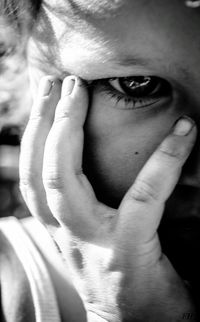 Close-up portrait of woman covering face with hands