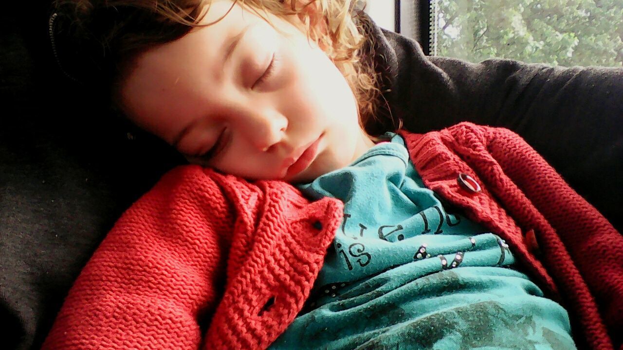 PORTRAIT OF CUTE GIRL LYING DOWN ON SOFA