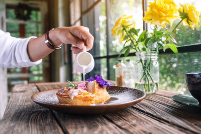 Midsection of person holding drink on table