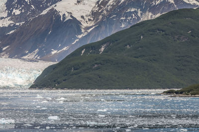 Scenic view of sea by mountains during winter