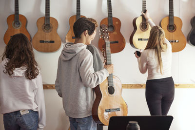 Teenagers attending guitar lesson