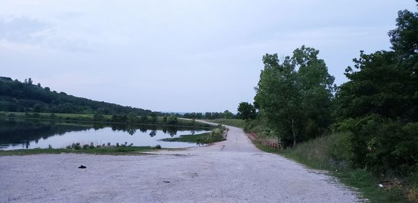 Road by lake against sky