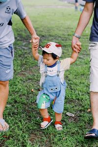 Boy holding hands walking in park