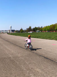 Woman riding motorcycle against clear sky